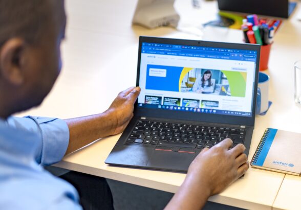 a man looking at a laptop with the amfori Academy on screen