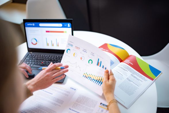 two persons looking at printed documents and dashboards