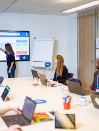Woman presenting a world map to colleagues in a meeting room