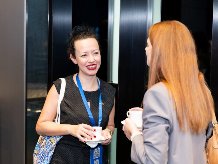 two women talking and smiling at each other